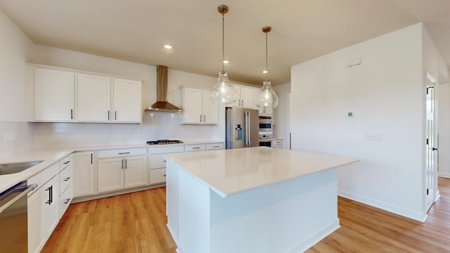 kitchen featuring stainless steel appliances, wall chimney exhaust hood, light wood-style flooring, a center island, and recessed lighting
