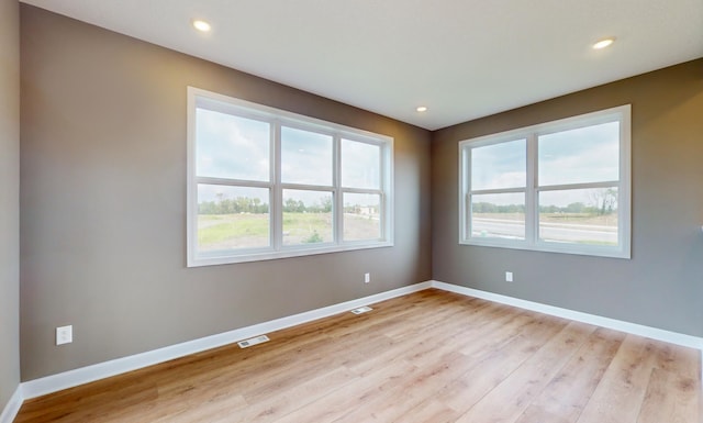 unfurnished room with plenty of natural light, light wood-style floors, baseboards, and recessed lighting