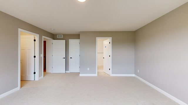 unfurnished bedroom with light colored carpet and baseboards
