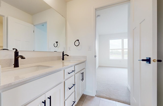 bathroom with tile patterned floors, double vanity, and baseboards
