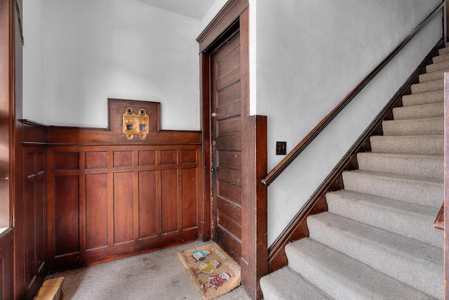 822 35th St, Minneapolis, MN 55408 - staircase featuring carpet, wainscoting, and wooden walls