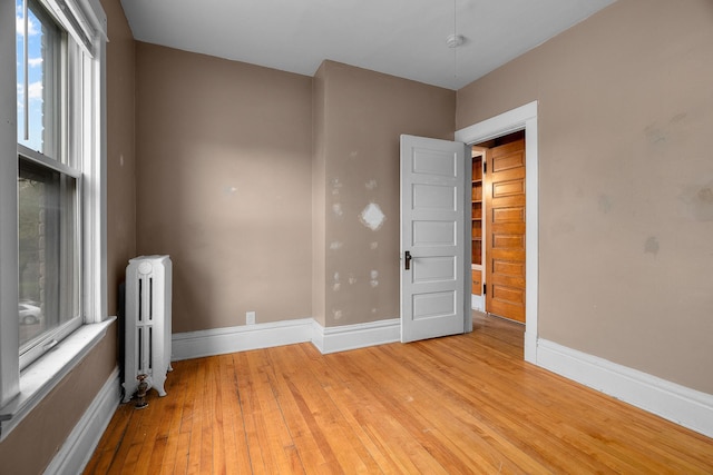 822 35th St, Minneapolis, MN 55408 - empty room featuring radiator heating unit, hardwood / wood-style floors, baseboards, and plenty of natural light