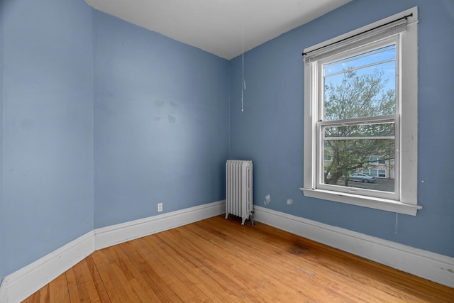 822 35th St, Minneapolis, MN 55408 - empty room featuring radiator heating unit, healthy amount of natural light, baseboards, and wood-type flooring