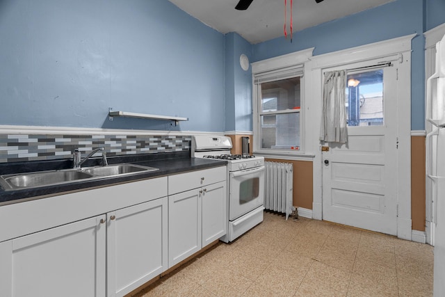 822 35th St, Minneapolis, MN 55408 - kitchen with white gas range oven, a sink, radiator, dark countertops, and ceiling fan
