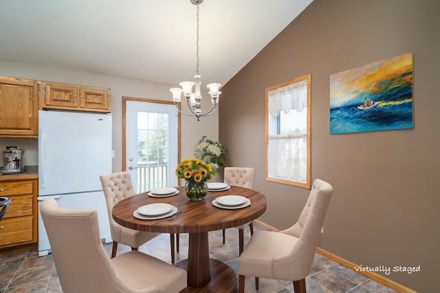 dining area with vaulted ceiling, a chandelier, and baseboards