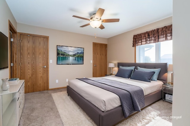 bedroom featuring light colored carpet and a ceiling fan