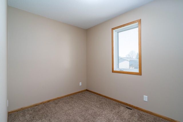 unfurnished room with carpet floors and baseboards