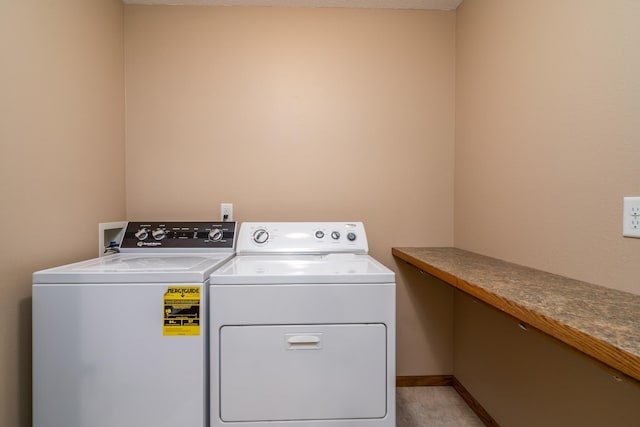 laundry area with washer and dryer and baseboards