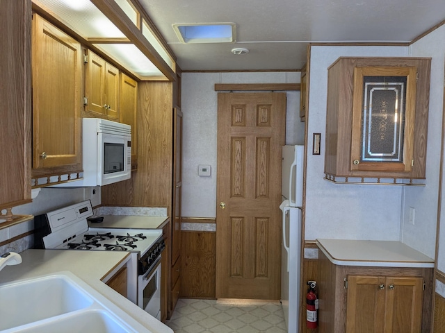 2221 Reubens Ln SW Unit 46, Farwell, MN 56327 - kitchen with white appliances, light countertops, brown cabinets, a sink, and crown molding