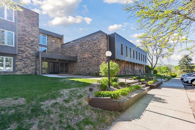450 Ford Rd Unit 231, Saint Louis Park, MN 55426 - view of home's exterior featuring a yard and brick siding