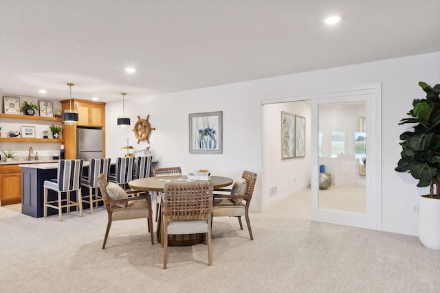 dining space with light carpet, recessed lighting, and baseboards
