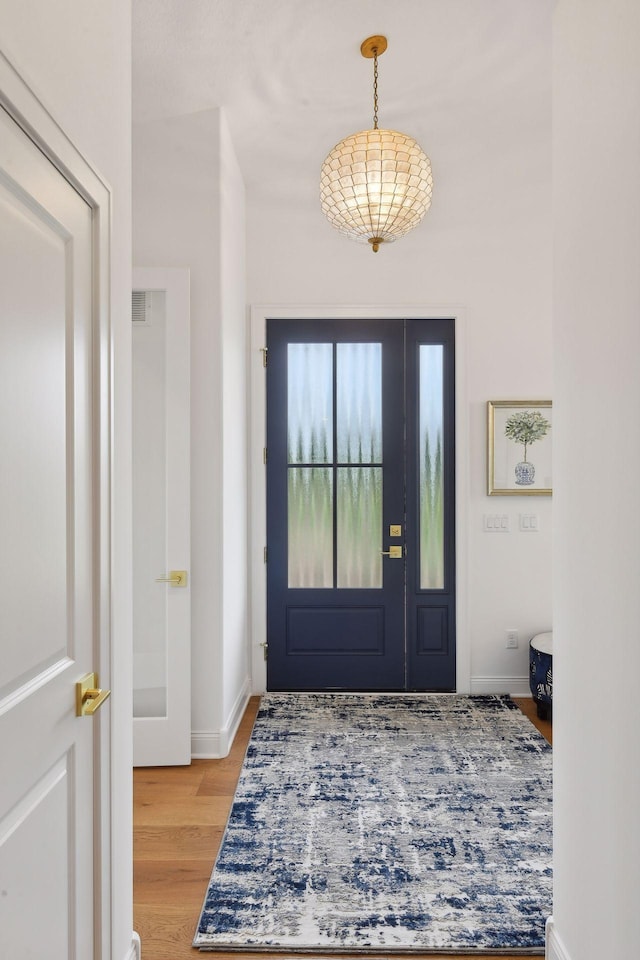 entryway with light wood finished floors and baseboards
