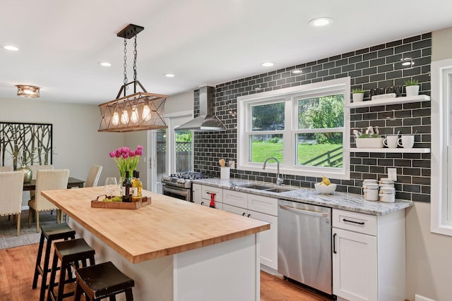 550 Wheeler Dr, Excelsior, MN 55331 - kitchen featuring appliances with stainless steel finishes, wall chimney range hood, a sink, wooden counters, and open shelves