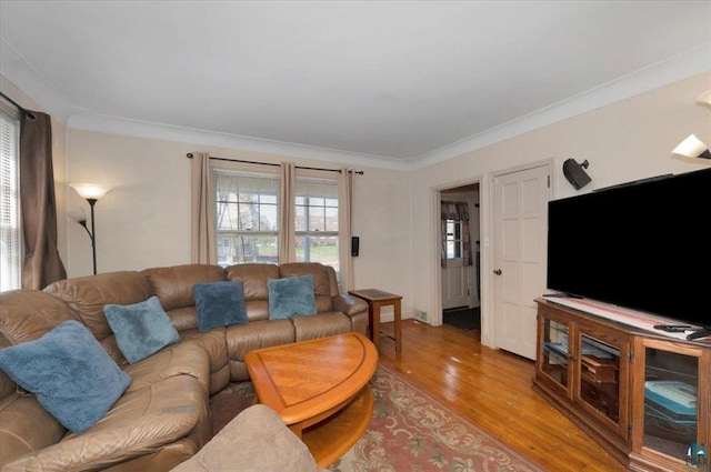 living room with light wood finished floors and ornamental molding