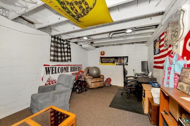 carpeted home office featuring concrete block wall