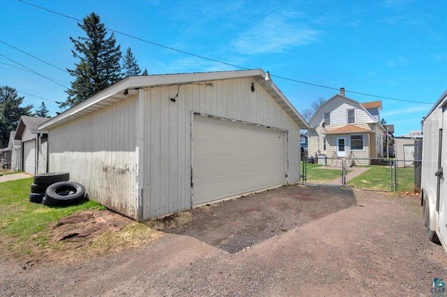 detached garage with fence and a gate