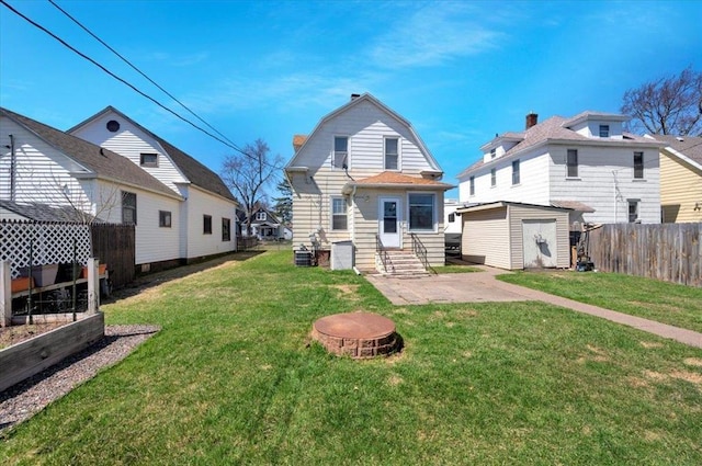 back of house featuring entry steps, a gambrel roof, a storage unit, an outdoor structure, and a patio area