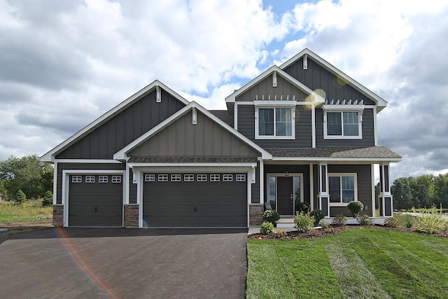 19587 Hammock Ave, Lakeville, MN 55044 - craftsman house with board and batten siding, a shingled roof, a front lawn, asphalt driveway, and a porch