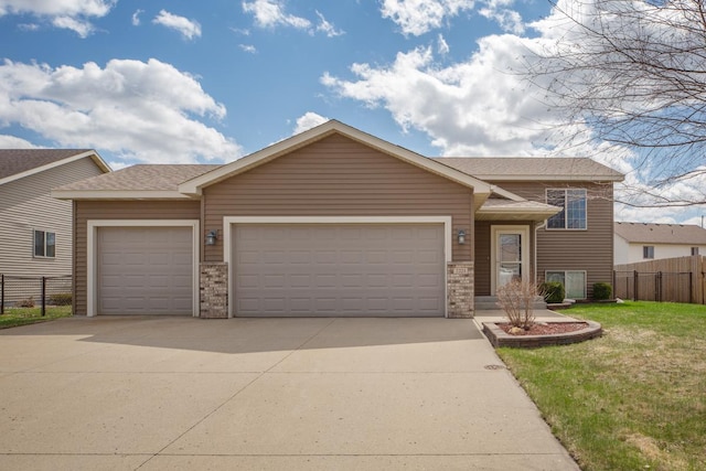 split level home with a garage, concrete driveway, brick siding, and a shingled roof