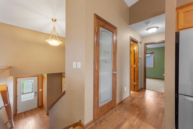 hall with light wood-type flooring and baseboards
