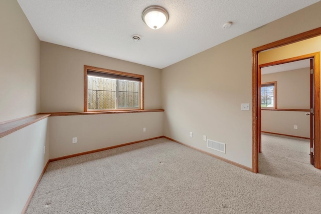 empty room featuring carpet, plenty of natural light, and baseboards