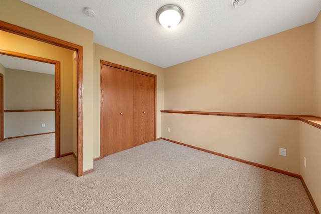 unfurnished bedroom featuring carpet, a closet, and baseboards