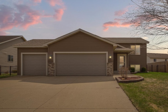 tri-level home featuring a garage, concrete driveway, brick siding, and a shingled roof