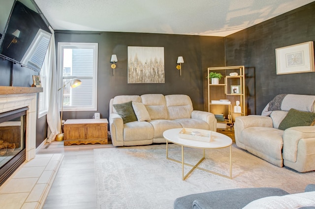 living room with wood finished floors, a fireplace, and a textured ceiling