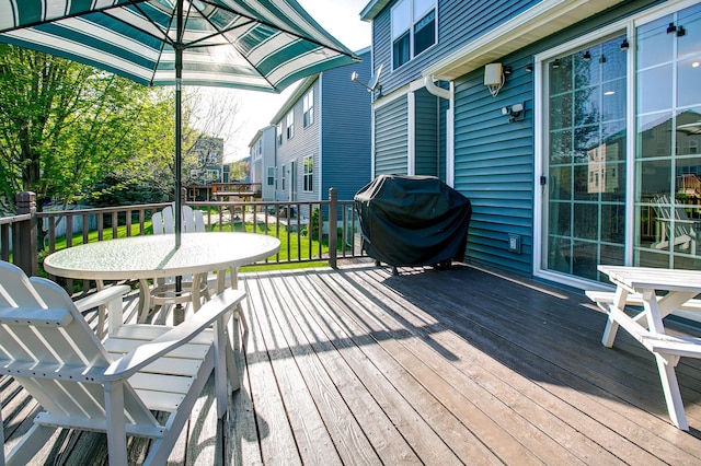 wooden deck featuring a grill, outdoor dining area, and a residential view