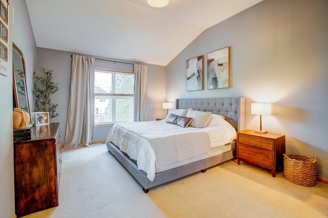 bedroom featuring light carpet, lofted ceiling, and baseboards