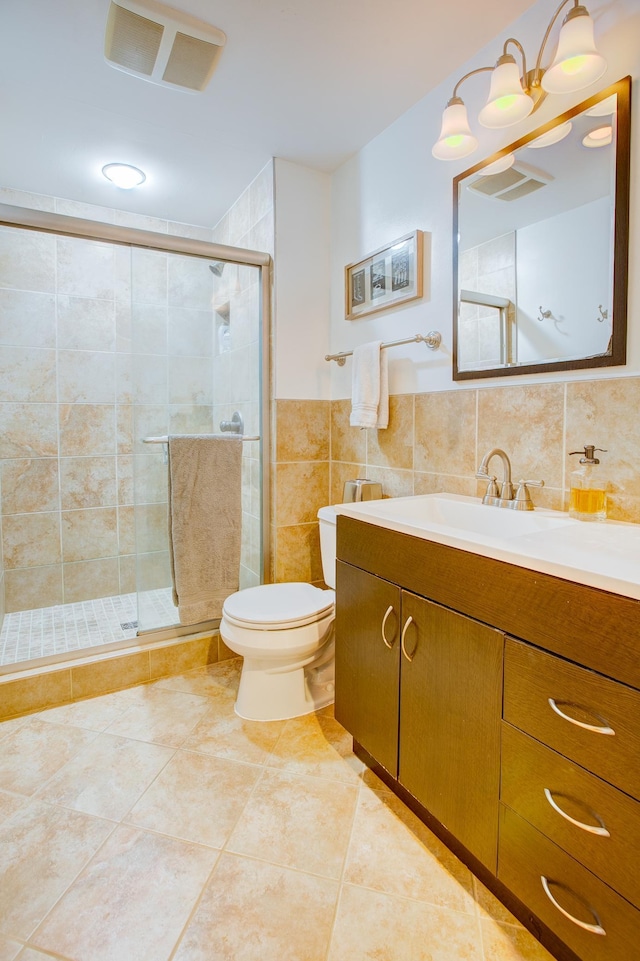 full bath featuring tile walls, a shower stall, toilet, tile patterned flooring, and vanity