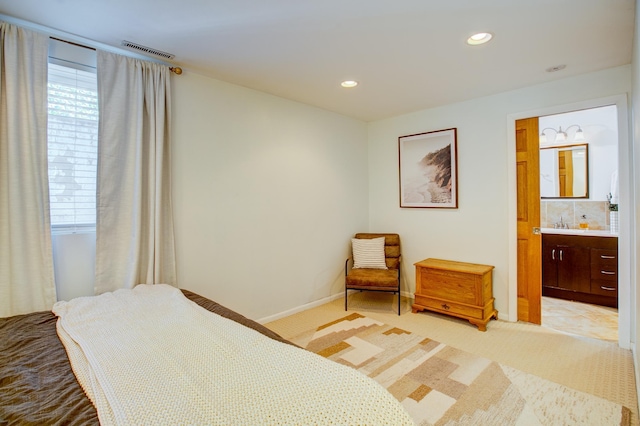 bedroom with light carpet, recessed lighting, baseboards, and ensuite bath