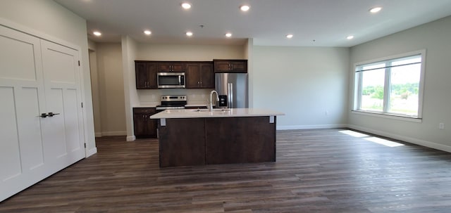 715 Lake Shore Dr NE Unit 108, Bemidji, MN 56601 - kitchen with stainless steel appliances, an island with sink, baseboards, dark brown cabinets, and light countertops