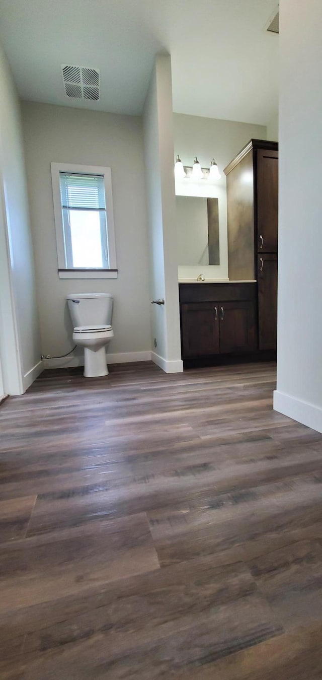 715 Lake Shore Dr NE Unit 108, Bemidji, MN 56601 - bathroom featuring toilet, baseboards, wood finished floors, and vanity