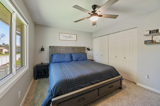 carpeted bedroom with multiple windows, baseboards, a ceiling fan, and a closet