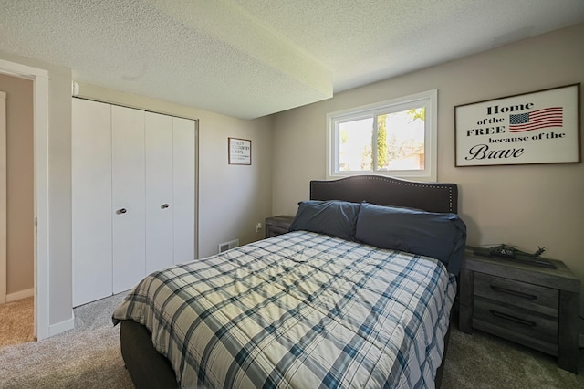 carpeted bedroom with a closet and a textured ceiling