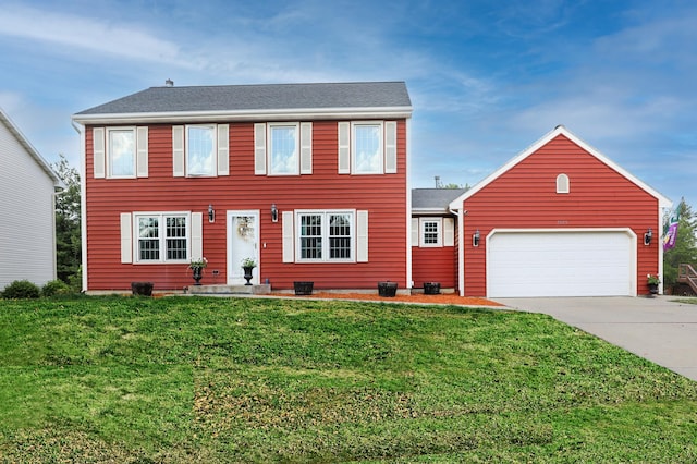 colonial-style house with an attached garage, a front yard, and driveway