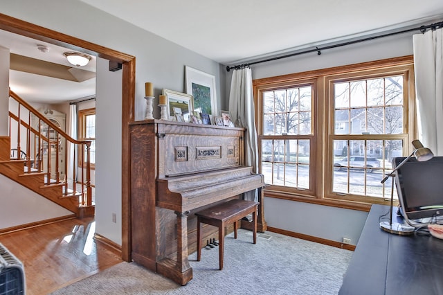 living area featuring baseboards, stairway, and wood finished floors
