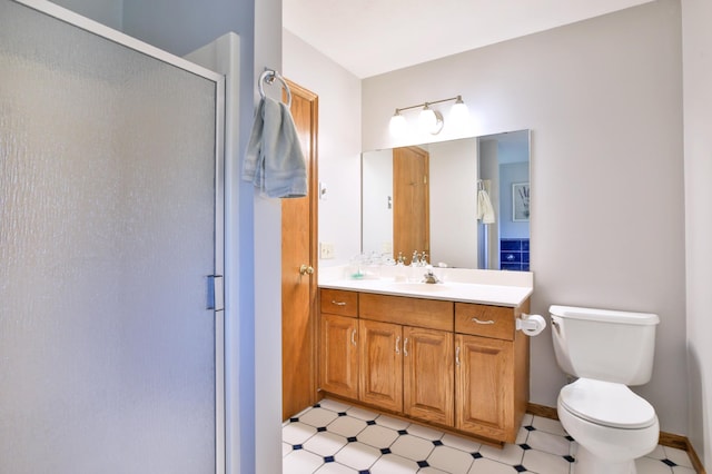 bathroom with a stall shower, toilet, vanity, tile patterned floors, and baseboards