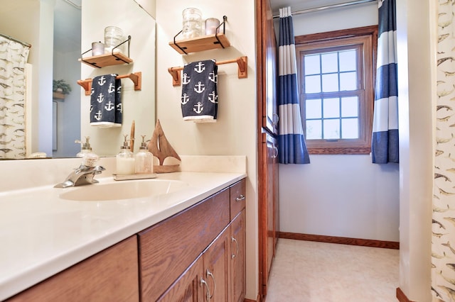 bathroom with tile patterned floors, baseboards, and vanity