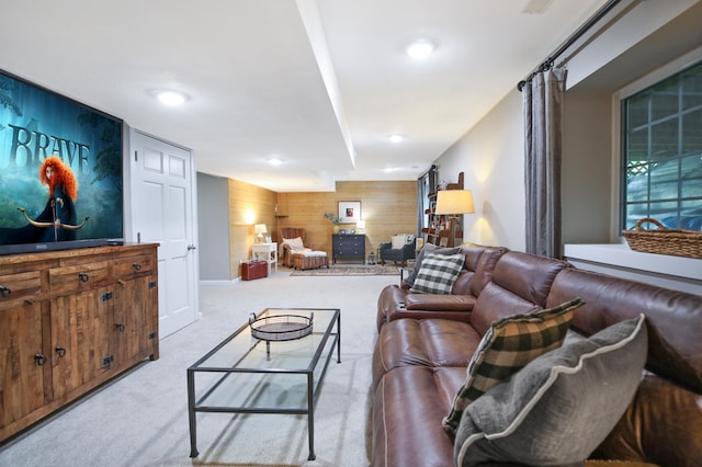 living area featuring wood walls, carpet, and an accent wall