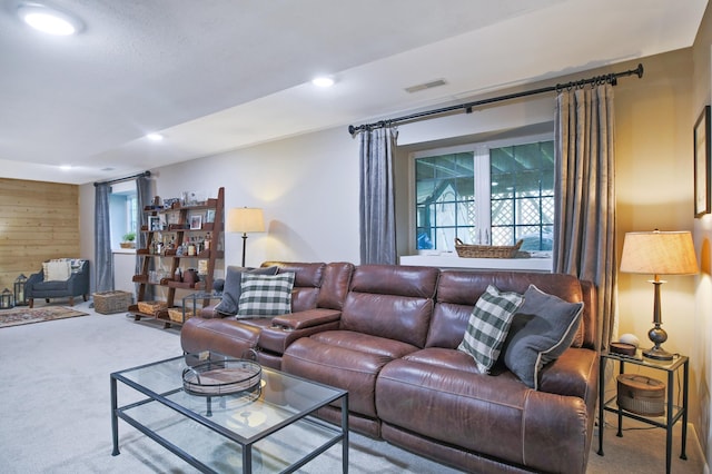 carpeted living room featuring wood walls and recessed lighting