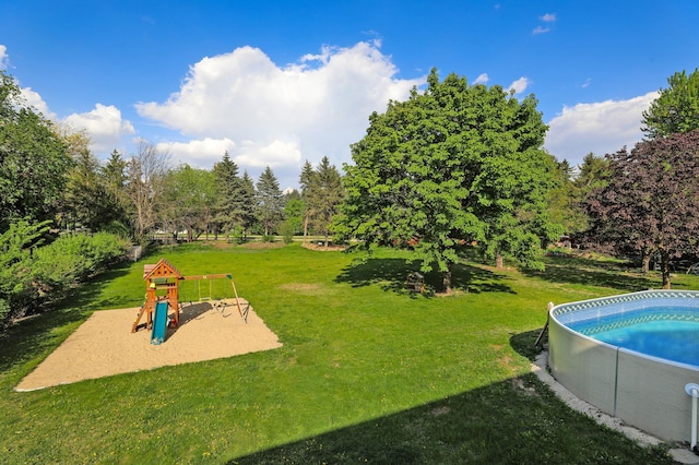 swimming pool with a playground and a lawn