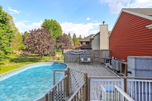 outdoor pool featuring a wooden deck and cooling unit