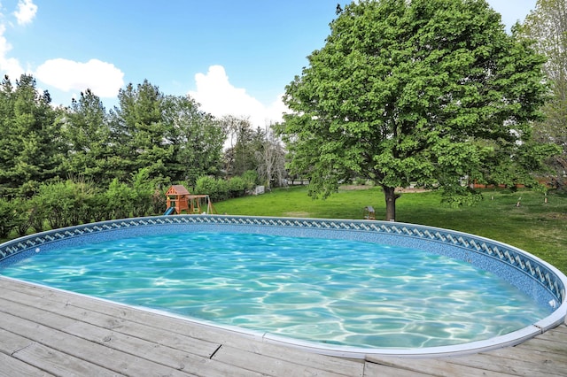 view of pool featuring a yard and view of wooded area