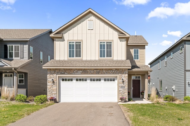 craftsman house with driveway, stone siding, a garage, board and batten siding, and roof with shingles