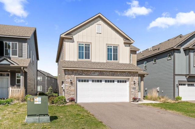 view of front of home featuring board and batten siding, stone siding, asphalt driveway, and a garage
