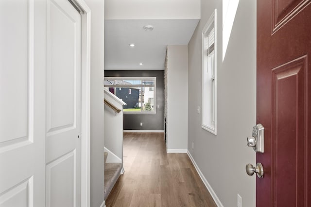 entrance foyer with wood finished floors, baseboards, stairway, and recessed lighting
