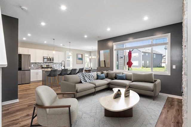 living room with wood finished floors, recessed lighting, and baseboards