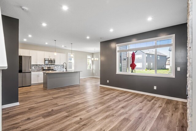 kitchen featuring stainless steel appliances, a sink, white cabinets, recessed lighting, and light wood-style flooring